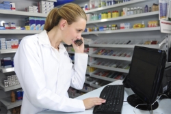 pharmacist looking at a desktop computer while on call