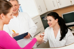 lady handling her health insurance card to a nurse