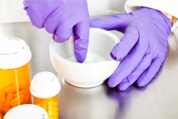 pharmacist's hands using a mortar and pestle