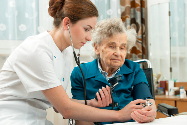 nurse doing a blood pressure check of an elder woman