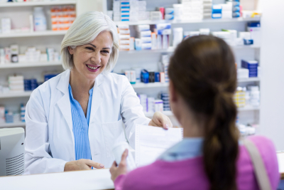 Pharmacist giving prescriptions of medicine to customer in pharmacy